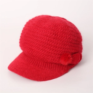 Nahaufnahme der roten Strickstruktur und des Bommel-Details an der Wintermütze