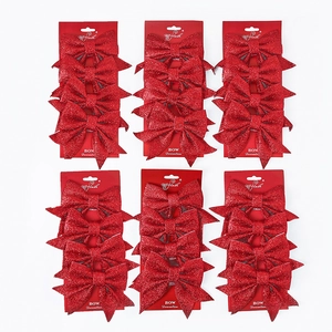 Close-up of sparkling red glitter Christmas bows in six retail packs for tree decoration