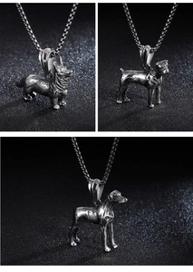 Detailed close-up of three vintage silver dog pendants on chains against a black background