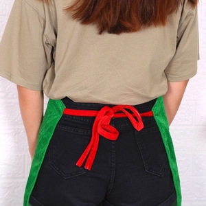 Green Christmas kitchen apron with red bow-tie back strap for holiday parties
