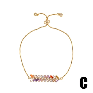 Macro detail of rainbow baguette cut zirconia on gold adjustable chain bracelet