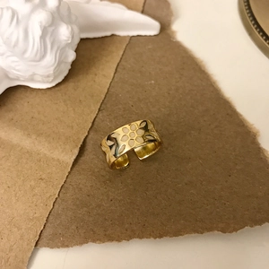 French vintage style wide gold flower ring with white resin petals on artistic background