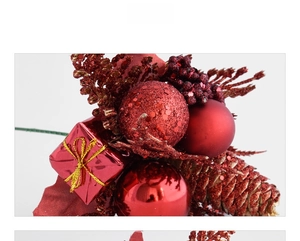 Macro detail of red Christmas pick with glitter pine cone, shiny baubles and gift box