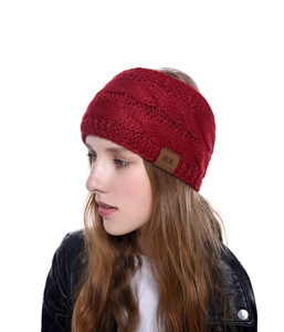 Vue détaillée d'un bandeau en maille torsadée rouge foncé avec écusson MOK sur un mannequin.