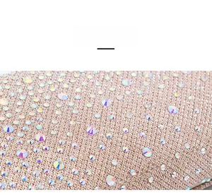 Macro shot of shimmering AB rhinestones on champagne mesh fabric for evening bags