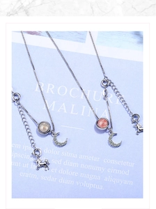 Detailed close-up of moon and unicorn pendants with pink and white gemstones