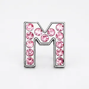 Close-up of a silver letter M charm slider with sparkling inlaid pink rhinestones