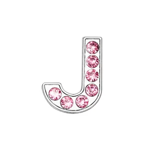 Macro shot of chrome letter J charm with seven inlaid pink crystals for DIY jewelry
