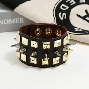 Macro detail of dark brown leather punk bracelet with gold studs and silver spikes