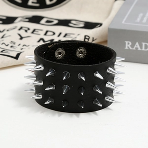 Detail of a punk leather bracelet with three rows of silver metal spikes and snap buttons