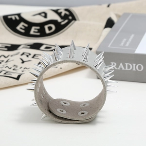 Detail of punk leather bracelet showing silver cone spikes and adjustable snap buttons