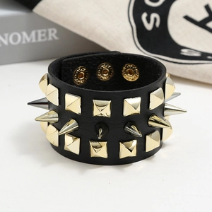 Detail of black punk leather bracelet featuring sharp gold rivets and snap buttons