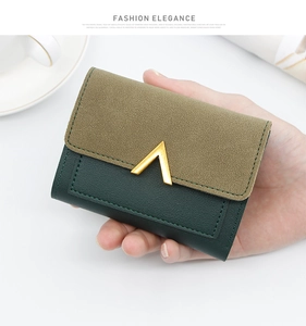 Close-up of green tri-fold mini wallet with V-shaped gold buckle and lychee texture