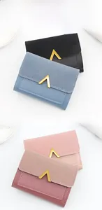 Close-up of minimalist tri-fold mini wallets in multiple colors with gold V-shape metal buckle