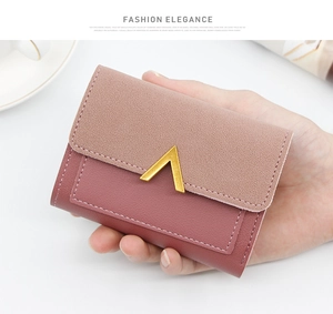 Detailed shot of a two-tone pink compact wallet with elegant V-shaped gold metal clasp