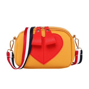Yellow pebble leather crossbody bag with red heart detail and striped woven strap