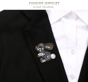Detail of rabbit brooch with black rhinestones and white pearl on black wool suit blazer