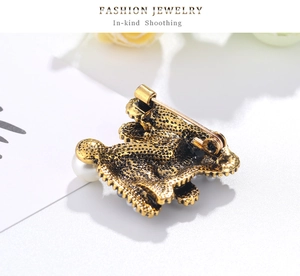 Detailed back view of vintage gold rabbit brooch showing safety pin and pearl detail
