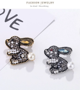 Detail of cute rabbit brooches with sparkling rhinestones and pearl accents in gold and silver