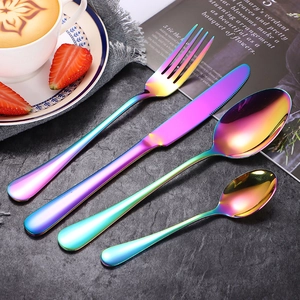 4-piece rainbow stainless steel cutlery set including fork, knife, and spoons on dark table