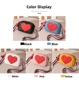 Close-up of heart-shaped crossbody bags in black, blue, white, pink and yellow options
