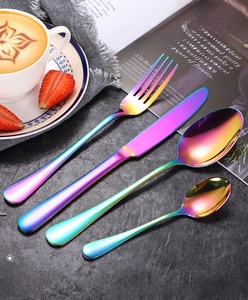 Rainbow stainless steel flatware set with colorful vacuum plating on dark stone surface