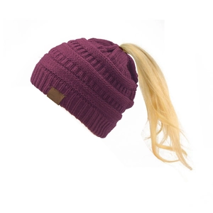 Dettaglio del berretto in maglia a trecce color bordeaux con apertura per coda