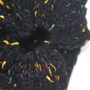 Dettaglio di un berretto nero lavorato a maglia con filati multicolori macchiati