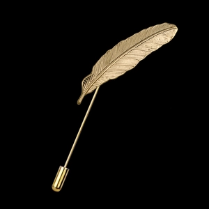 Detailed close-up of a golden feather lapel pin with intricate textures on black background