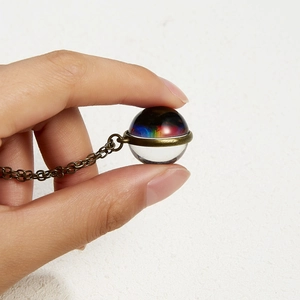 Close-up of luminous iridescent galaxy glass pendant on a vintage bronze chain necklace
