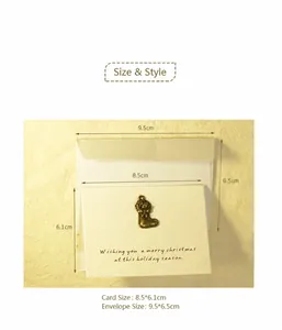Détail d'une mini carte de Noël avec pendentif en métal et son enveloppe blanche