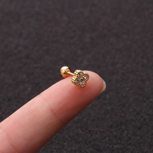 Macro shot of gold four-leaf clover screw-back earring with clear cubic zirconia stone
