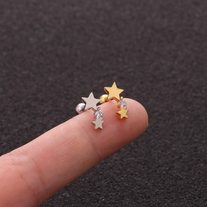 Close-up of curved barbell stud earring with stars and cubic zirconia on fingertips