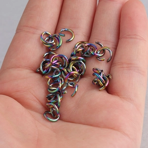 Rainbow stainless steel open jump rings for DIY jewelry making held in a hand