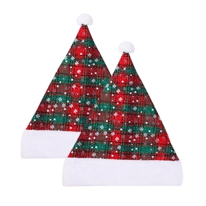 Close-up of red and green plaid Christmas hats with snowflake patterns and white plush trim