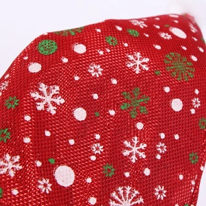 Macro view of thick red plaid fabric with white and green snowflakes for Christmas hat