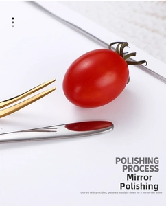 Close-up of mirror-polished stainless steel fruit forks and spoons in gold and silver
