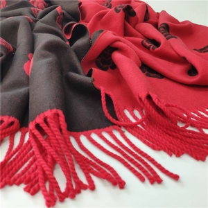 Detail view of double-sided camellia pattern cashmere-like scarf with fringe accents