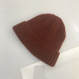 Detailed flat lay of caramel knit beanie showing textured ribbed stitching on wool fabric