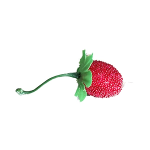 Artificial strawberry decorative accessory with red beadwork and green leaves on white