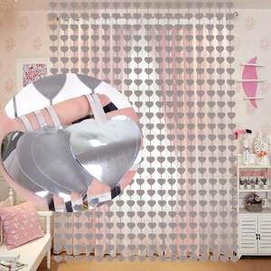 Close-up of silver heart-shaped sequins and reflective foil curtain for party decoration
