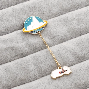 Detail of creative astronaut cat and planet enamel brooch with gold chain on velvet