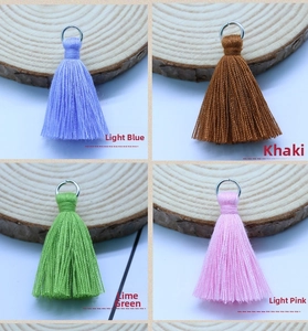 Detail of 3.5cm cotton tassels with metal rings in light blue, khaki, green and pink