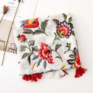 Close-up of ethnic floral print cotton scarf featuring red tassels and soft texture
