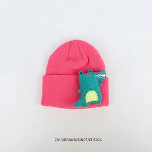 Detailansicht der rosaroten Strickmütze mit grünem 3D Cartoon Dinosaurier Stickaufnäher