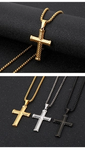 Gros plan détaillé montrant des pendentifs croix en or, argent et noir en comparaison tricolore