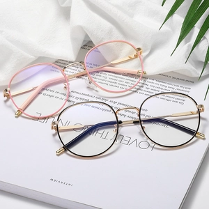 Retro round metal glasses frames in pink gold and black gold on white fabric