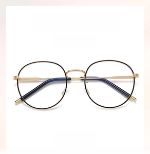Detail of round black metal spectacle frame with gold temples and blue light blocking lenses