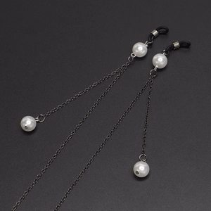 Detail of silver chain eyewear strap with white pearls and rubber loops on grey background