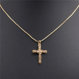 Close-up of gold-plated cross pendant necklace featuring micro-set zircon stones